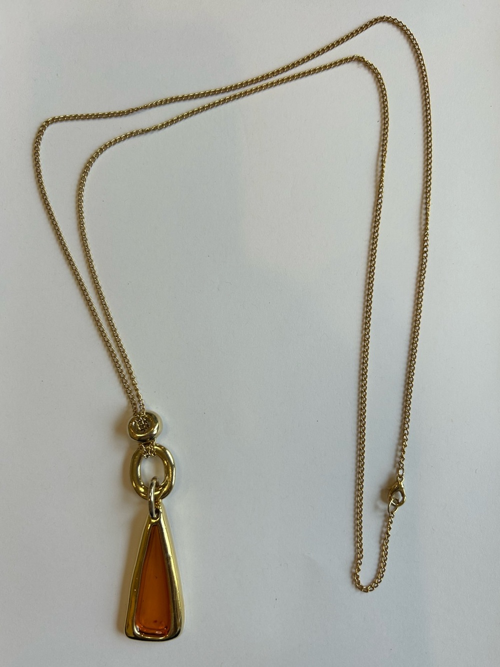 38”L, 2mm gold-tone chain with triangular amber glass(?) pendant.  Soho Design??